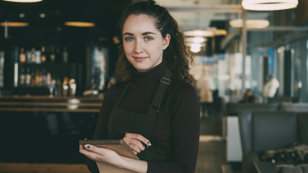 A café owner holding a notepad