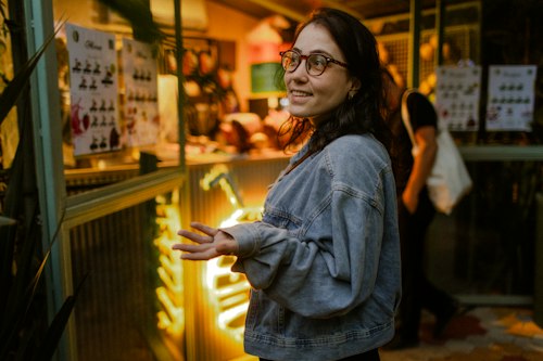 A shop owner chatting near a neon sign